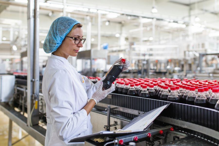 Quality technician inspecting bottles on the production line